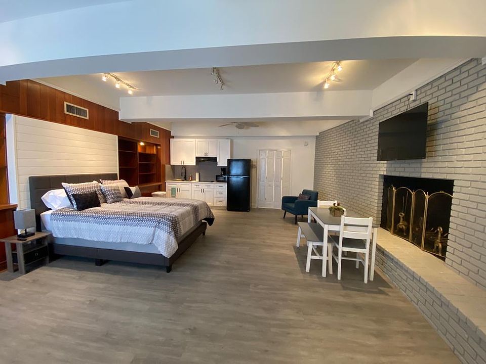 Bright, stylish studio with queen bed, workspace, and cozy dining area.