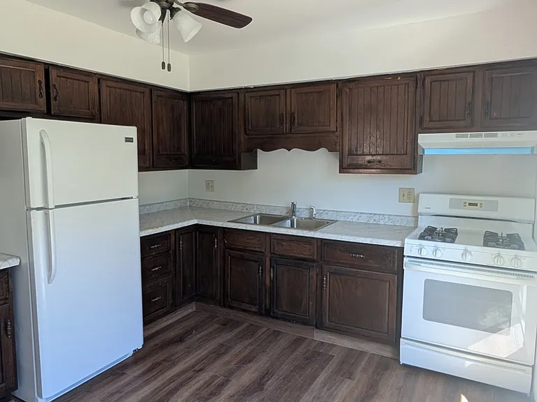 Spacious eat-in kitchen with gas range, ample cabinet storage, and new flooring.
