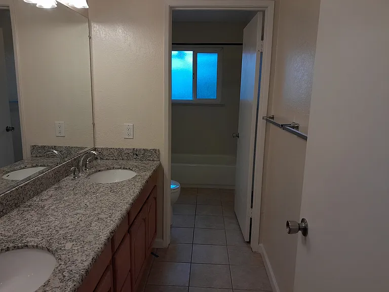 Hallway Bathroom with marble countertop, shower-tub combo, and tile floor