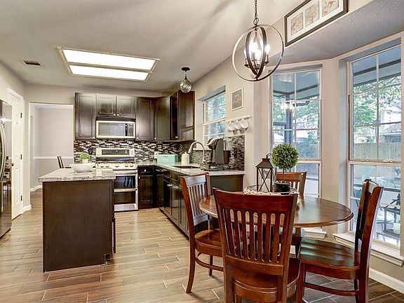 The perfect spot to start your day, overlooking the screened in porch and your beautiful backyard! Lovely side-by-side refrigerator will stay as well!