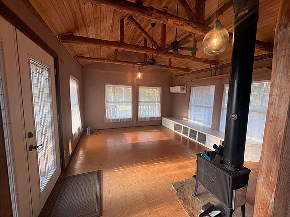 Living room - Sunny and rustic with open beam ceiling, a Jotul wood stove and mini split heating & air.