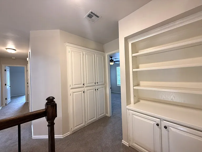 At the top of the landing coming up the stairs, are two separate storage areas. One is a bookshelf for books or displays and the rest is for stoarge.