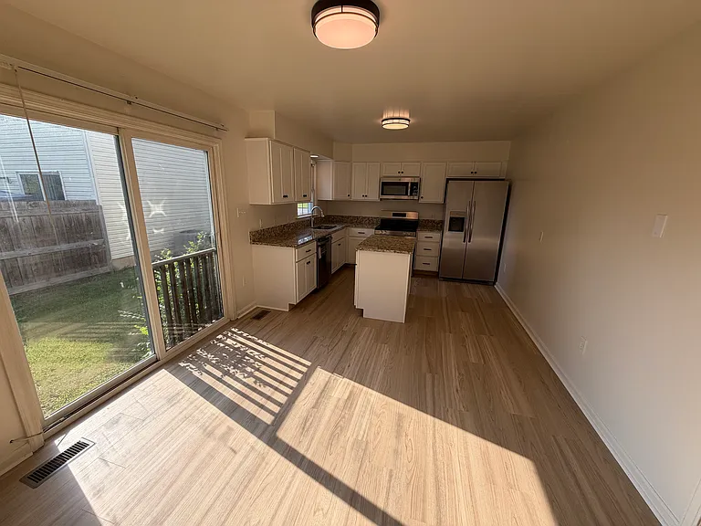 Dining area conveniently open to kitchen with sliding glass doors showcasing natural light