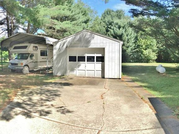 The garage offers added storage with a newer 18x32 carport to protect an RV or camper.
