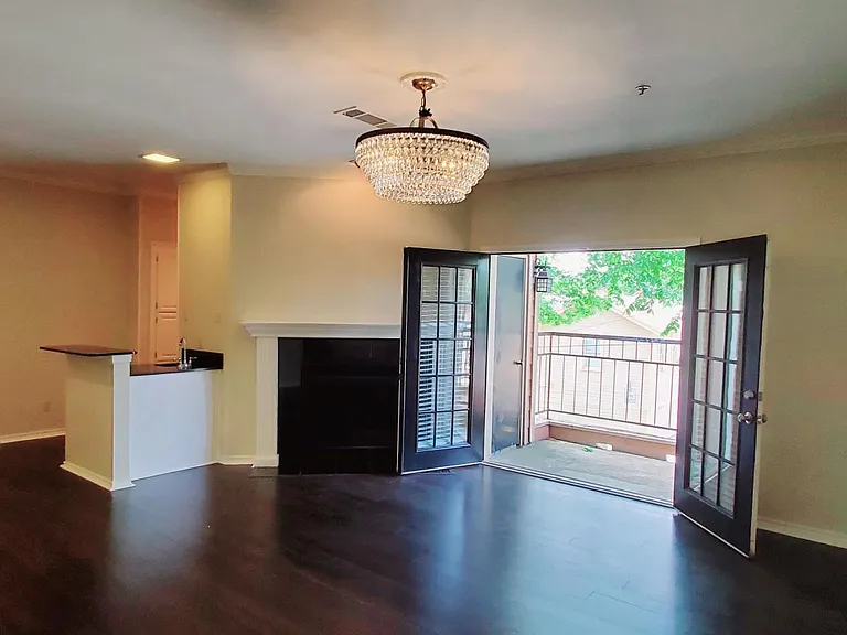 Spacious living area with patio overlooking quiet tree line street.