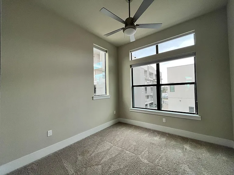 Second bedroom with blackout blinds and ceiling fan