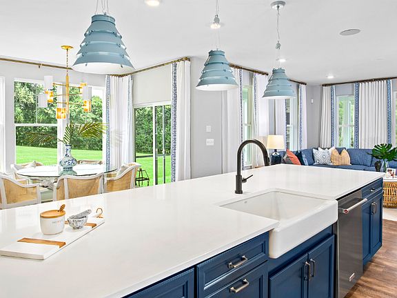 Open kitchen with large island, adjacent dining area morning room in a DRB Homes St. Kitts Model Hom