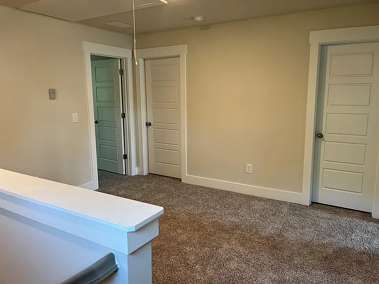 loft view with master door on left, laundry room door in center and guest full bath door on the right
