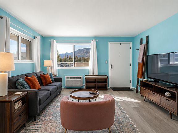 Soak in mountain views from this bright and welcoming living room _ a cozy retreat that feels both playful and peaceful the moment you arrive.