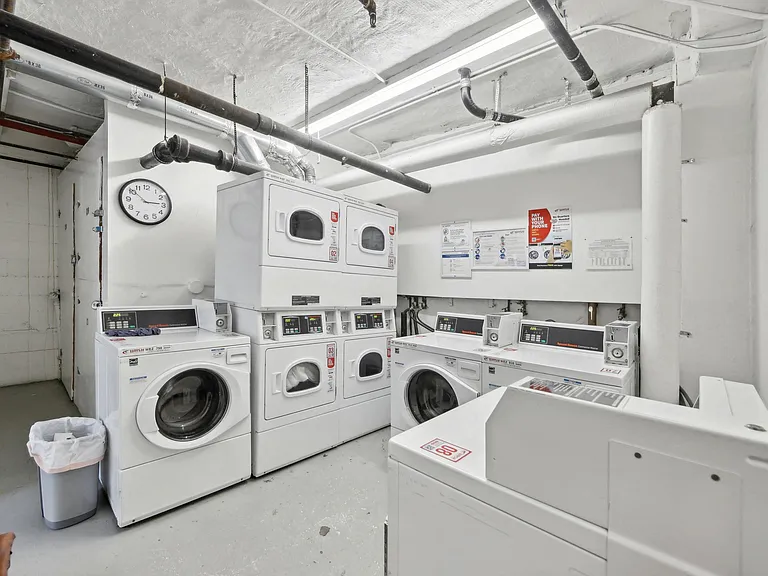 Laundry room with washing machines neatly arranged on a wooden floor