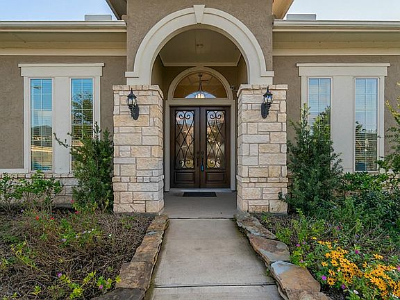 Decorative keystone at the peek of the arch with double wrought iron doors to greet guest at the welcoming entry.