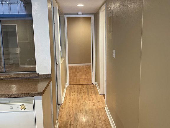 The hallway leading to the kitchen, atrium, bathroom, & bedroom