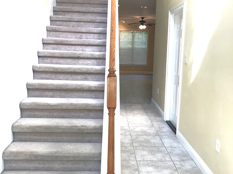 Entry Hallway. Tile flooring though-out downstairs. Door on right goes to garage. Stairway to laundry closet (doors at top of stairs). Upstairs is Master bedroom with walk in closet, au suite master bathroom, two additional bedrooms and hall bathroom.