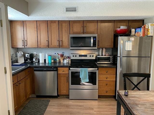 Unit 4 remodeled kitchen featuring upgraded cabinets, stainless steel appliances, and tiled backsplash
