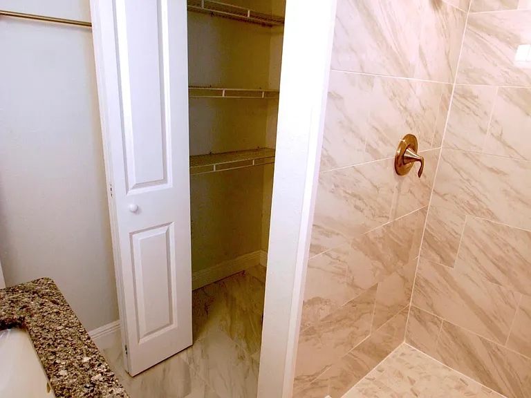Bathroom storage shelving can be seen in closet, also holds the hot water heater