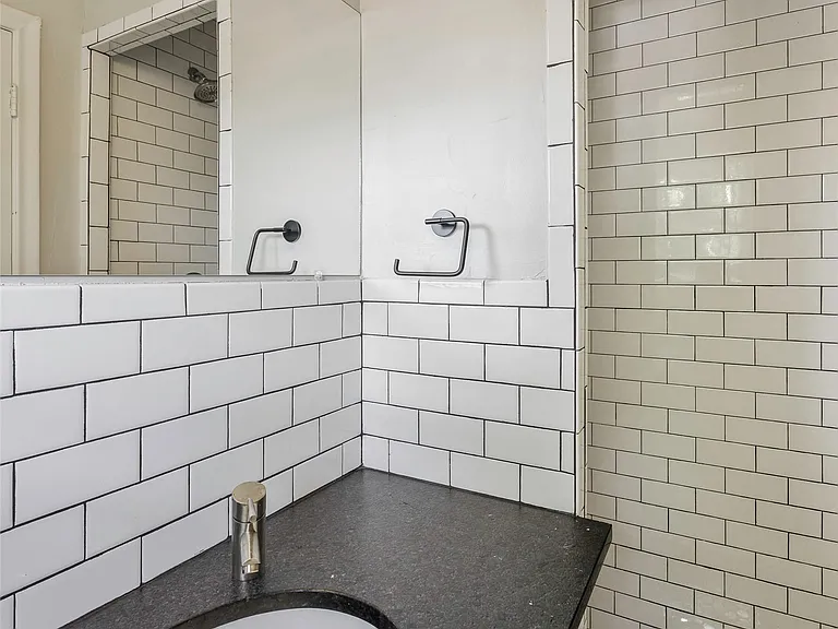 Master Bathroom featuring a tile shower, tile walls, and large vanity