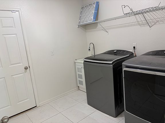 Laundry room close to the garage entry door, with a sink and washer-dryer.