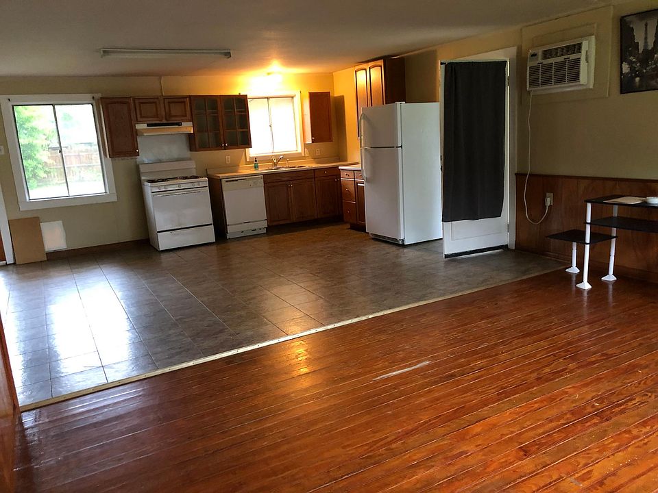 Open kitchen and dining area overlooks den with picture window. Back kitchen door opens to deck of back yard.
