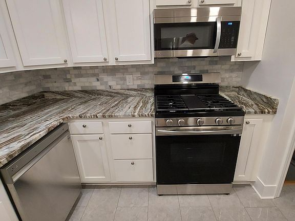 Brand new stainless appliances including dishwasher and gas stove.