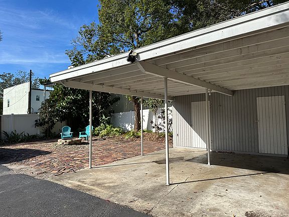 Carport with large outdoor storage closet.