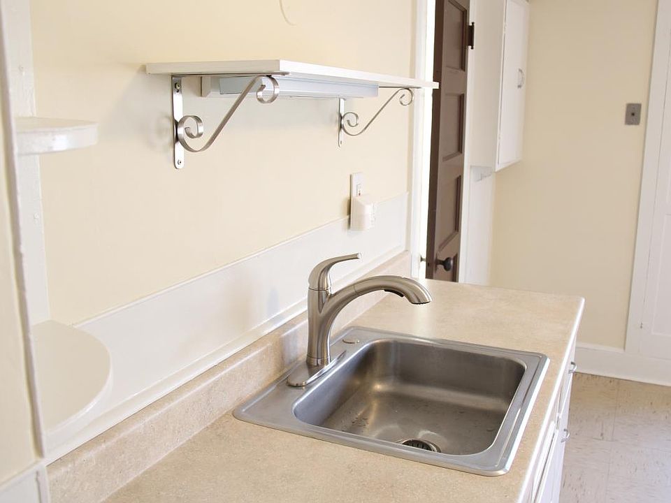 Well lit kitchen with modern faucet and large countertop. Lots of storage spaces! Note: Kitchen floor replaced after this picture - see beautiful upgraded flooring next.