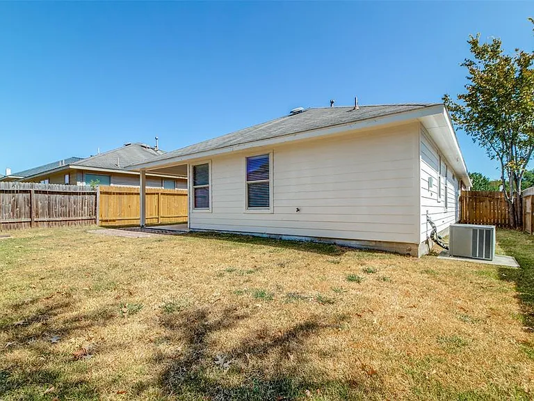 Fenced back yard, covered porch under roof.