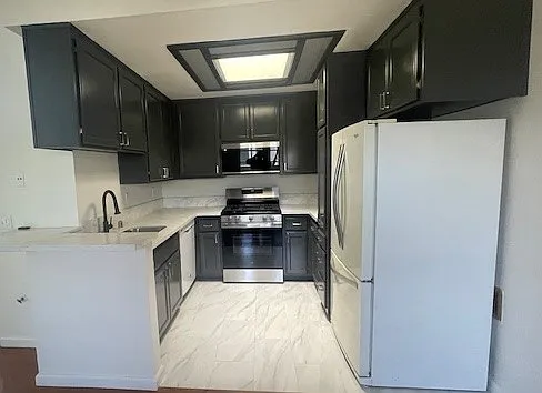 Kitchen with new appliances, sink and granite countertops. Freshly renovated and painted cabinets