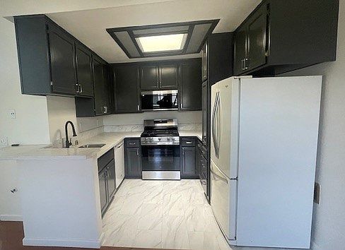 Kitchen with new appliances, sink and granite countertops. Freshly renovated and painted cabinets
