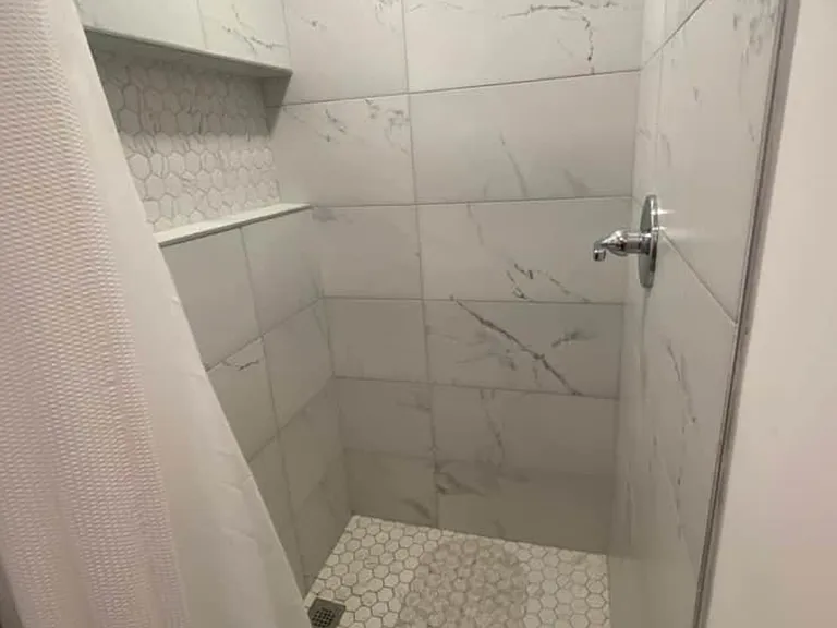 Enjoy a roomy shower with contemporary tile accents.