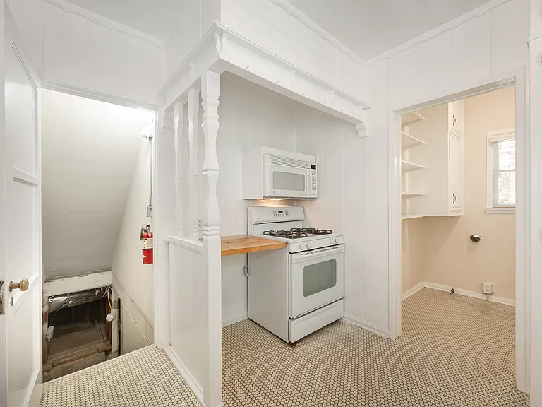 Kitchen Space with Microwave and Oven/Stove; Basement below and Laundry Room to the right