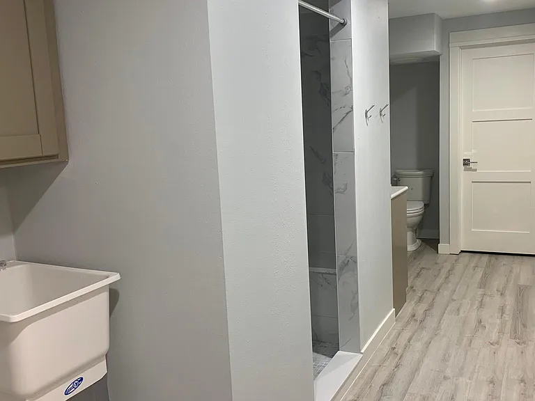 Lower level bathroom, newly tiled/upgraded shower and washer/dryer utility area