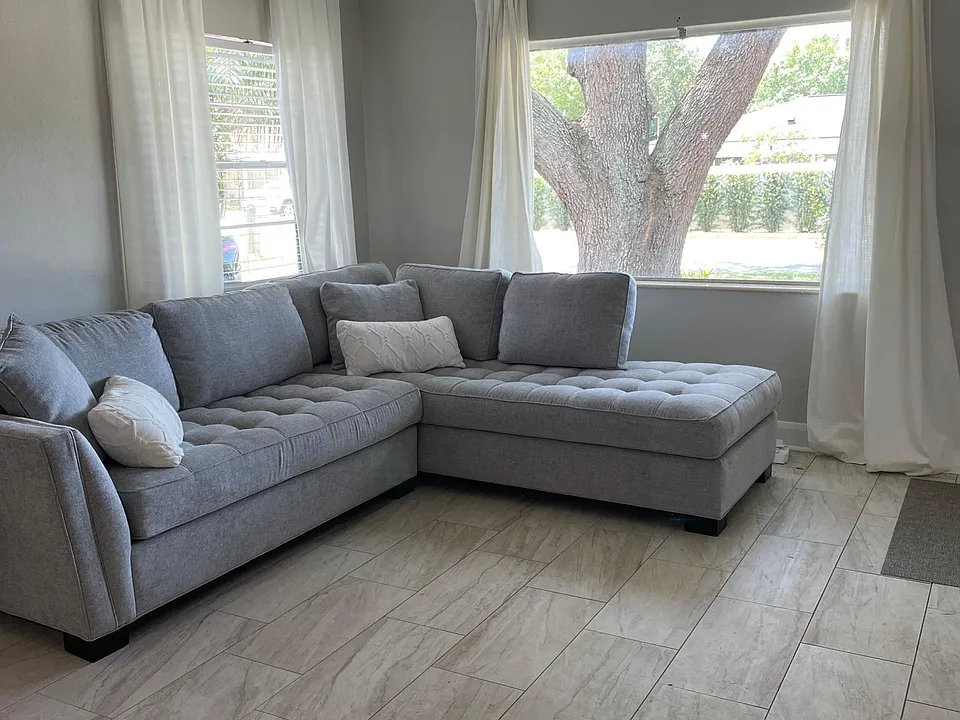 Beautiful grey sectional and gorgeous neutral tile flooring