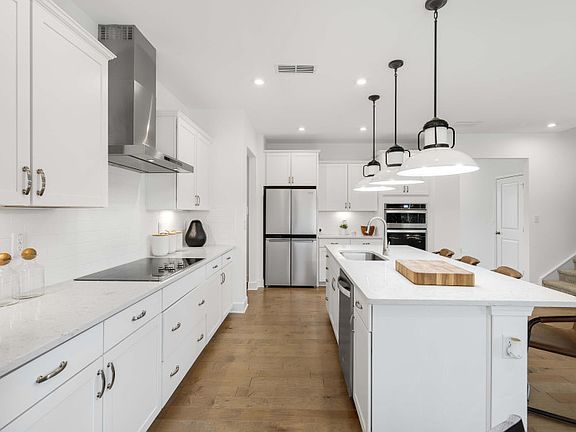 Gourmet kitchen with a center island and unique pendant lighting.