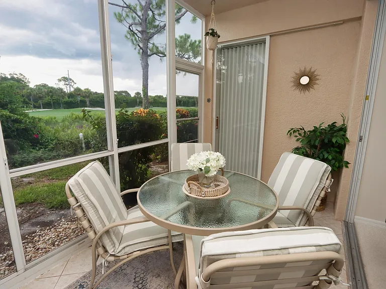 Back enclosed lanai overlooks the golf course and features an additional dining space w/four chairs, as well as two comfy wicker chairs to accommodate more guests. This space can be opened up to the living area by opening the sliding stacker doors.
