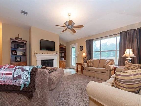 The living room features a cozy fireplace and large window overlooking the backyard.