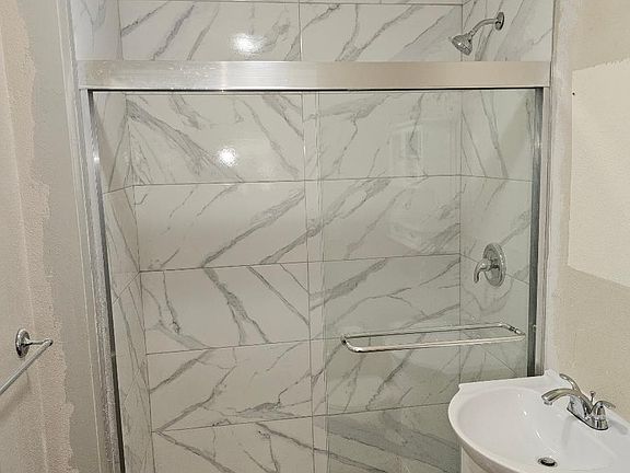 Brand new bathroom with upscale tile and glass sliding door, new vanity, floors and toilet