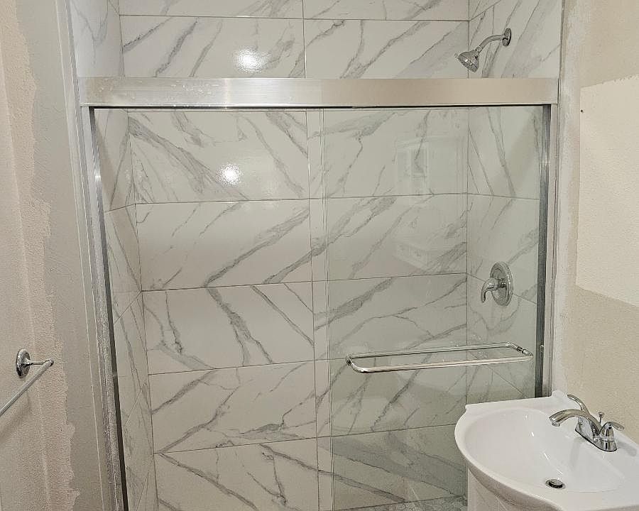 Brand new bathroom with upscale tile and glass sliding door, new vanity, floors and toilet