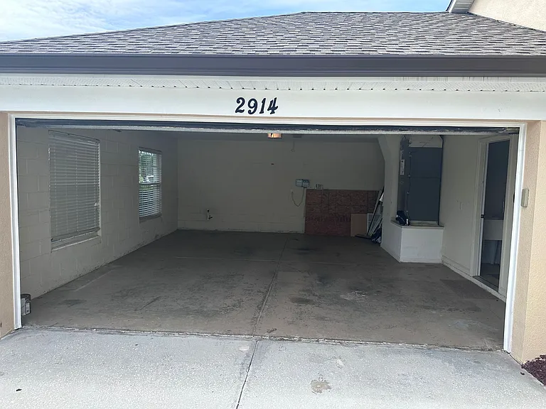 Clean interior of two-car garage _ ideal for storage and vehicles. (2023)