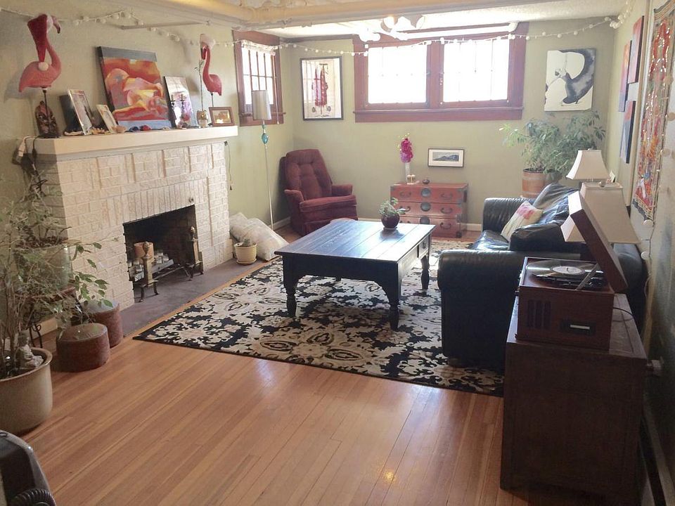 Living room with 4 large windows, hardwood floors & fireplac