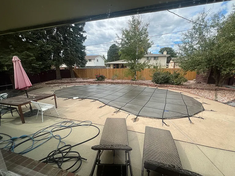 Rock-landscaped backyard with covered pool & multiple seating areas