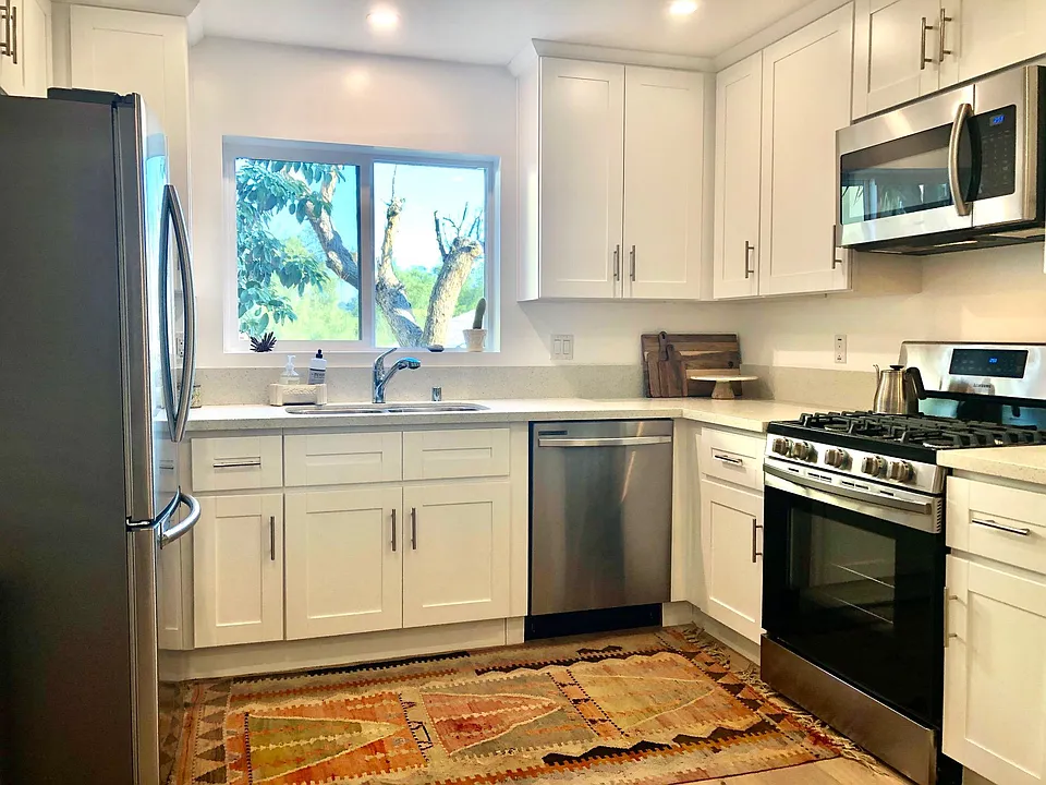 Fully stocked kitchen with dishwasher, garbage disposal, gas range, microwave, full size refrigerator, cookware and dishes. Kitchen window looks out onto private garden patio.