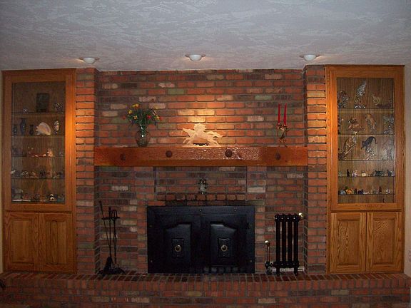 Wood burning fireplace with backlit custom cabinetry