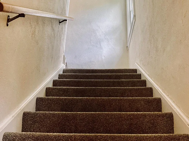 View of the stairs leading to the second full bathroom and bedrooms.