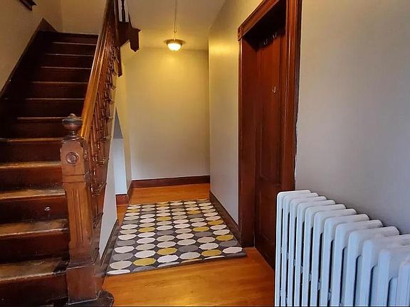 Front entrance with stairs to the left leading to the apartment with storage in hallway (not shown)