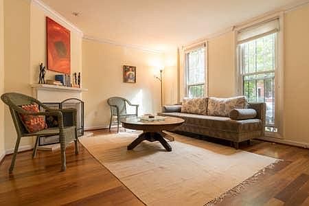 Spacious living room with wood-burning fireplace, new hardwood floors and large windows