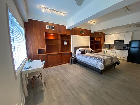 The room features a kitchen, Smart TV, and cozy, elegant decor.