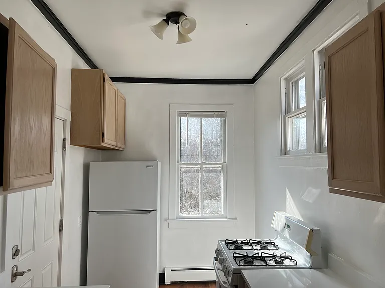 Kitchen.
1-West facing large kitchen window.
2-North facing windows.
Wood cabinets.