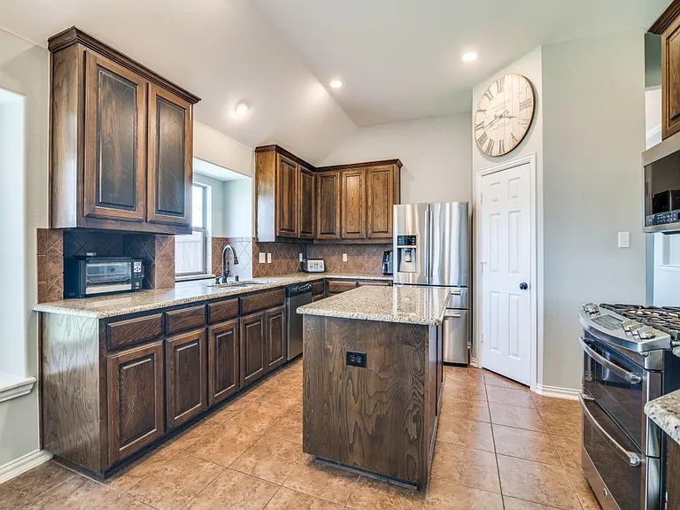 Open kitchen w gas stove top, frig.