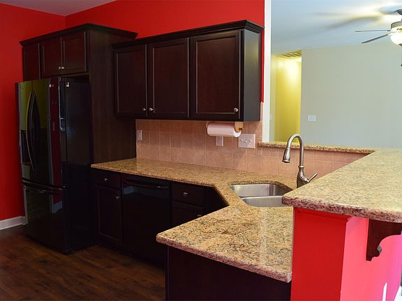 granite counter tops, dark wood cabinets and breakfast bar