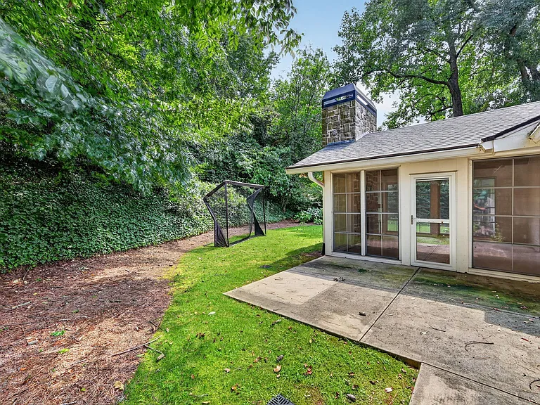 View of back patio off of 3-season porch. Additional door off of mudroom near garage.
